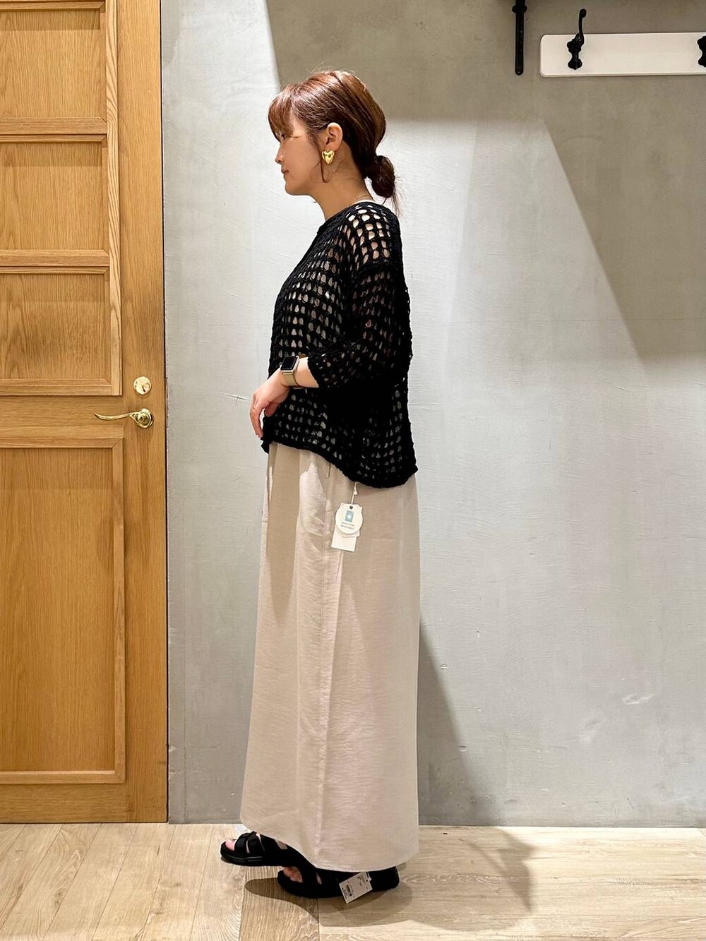 ベージュ系のその他パンツ、ブラック系のニット/セーター、ブラック系のサンダルを着用したレディースの春コーディネートの3枚目の写真