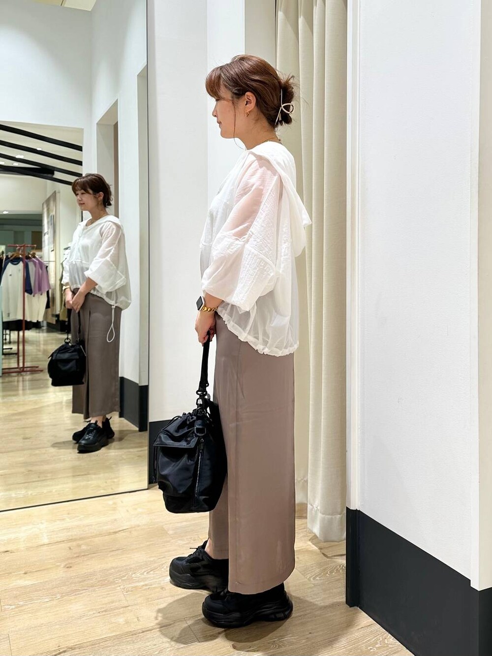 ブラック系のショルダーバッグ、ブラック系のスニーカー、ホワイト系のタンクトップを着用したレディースの秋コーディネートの3枚目の写真