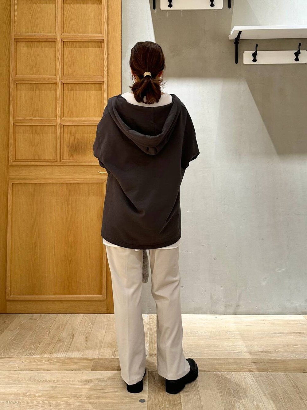 シルバー系のショルダーバッグ、グレー系のチュニック、ブラック系のブーツを着用したレディースの秋コーディネートの3枚目の写真