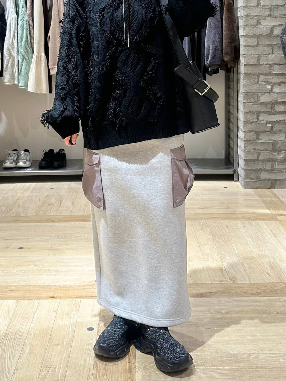 ブラック系のその他アウター、グレー系のスカート、ブラック系のショルダーバッグを着用したレディースの秋コーディネートの5枚目の写真