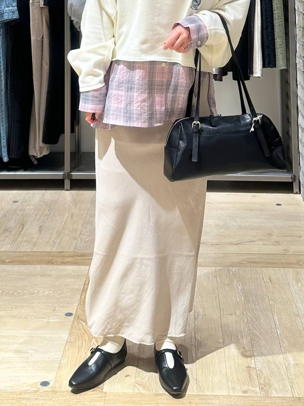 ブラック系のボストンバッグ、ベージュ系のスカート、ホワイト系のスウェットを着用したレディースの春コーディネートの5枚目の写真