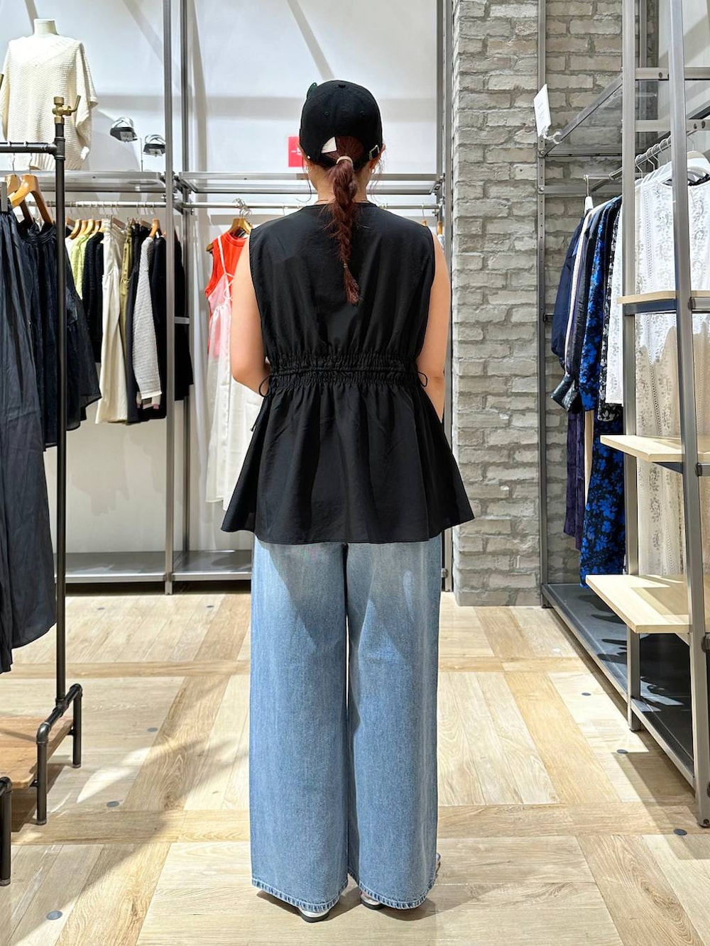 ブルー系のデニムパンツ、ブラック系のショルダーバッグ、グレー系のサンダルを着用したレディースの夏コーディネートの4枚目の写真