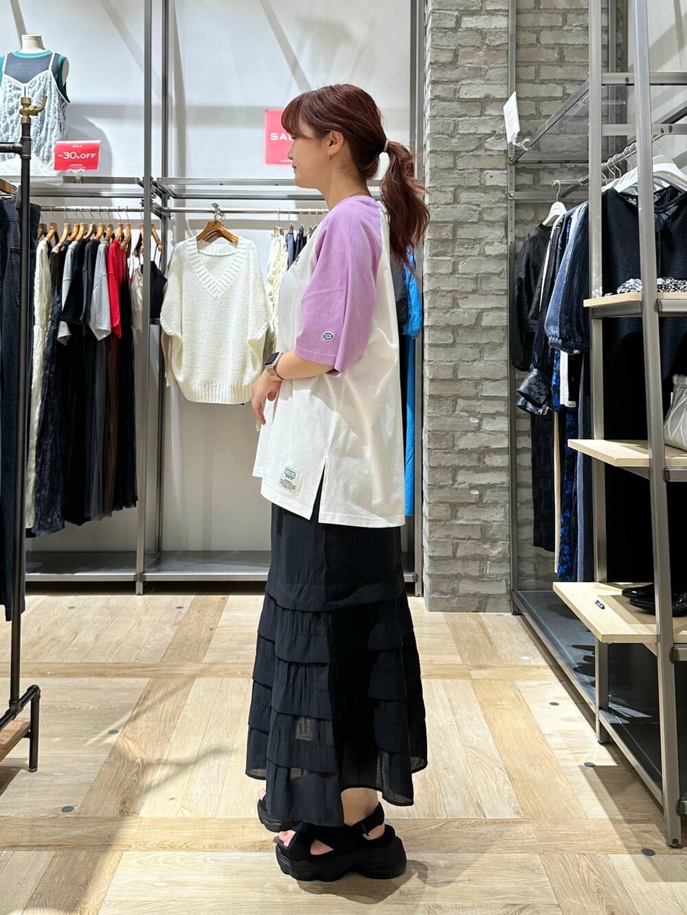 ブラック系のスカート、ブラック系のショルダーバッグ、ブラック系のサンダルを着用したレディースの夏コーディネートの3枚目の写真