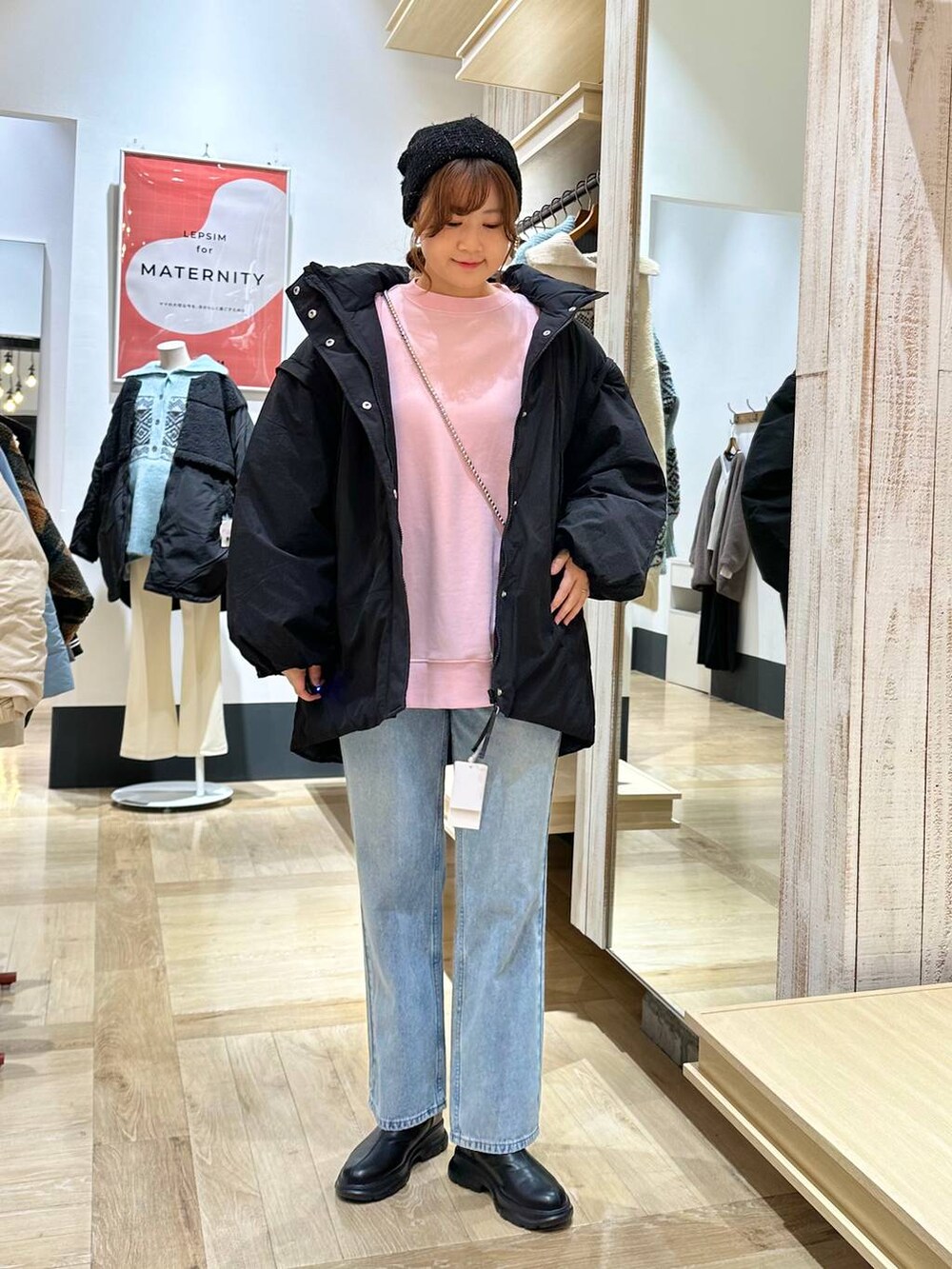 ブルー系のデニムパンツ、ブラック系のブーツ、ピンク系のスウェットを着用したレディースの冬コーディネートの5枚目の写真