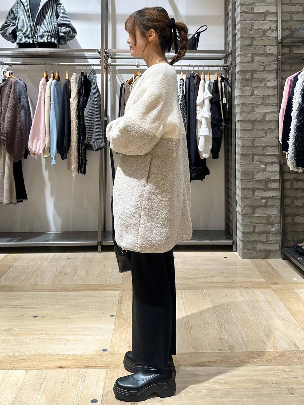 ブラック系のショルダーバッグ、ブラック系のスカート、ホワイト系のその他アウターを着用したレディースの秋コーディネートの9枚目の写真