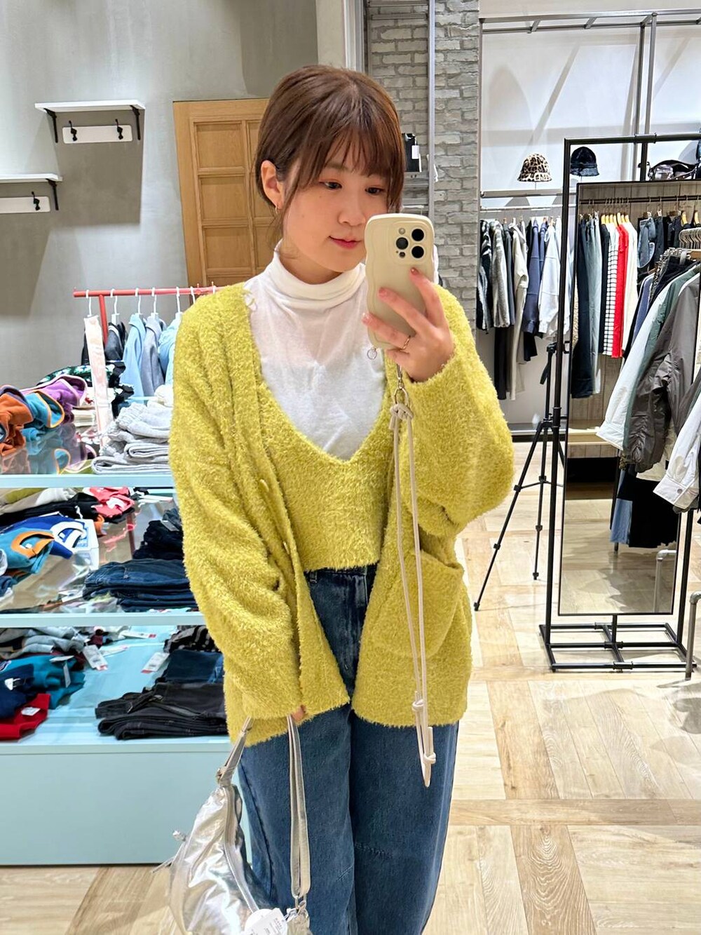 ホワイト系のTシャツ/カットソー、ブラック系のブーツ、ブルー系のデニムパンツを着用したレディースの冬コーディネートの4枚目の写真