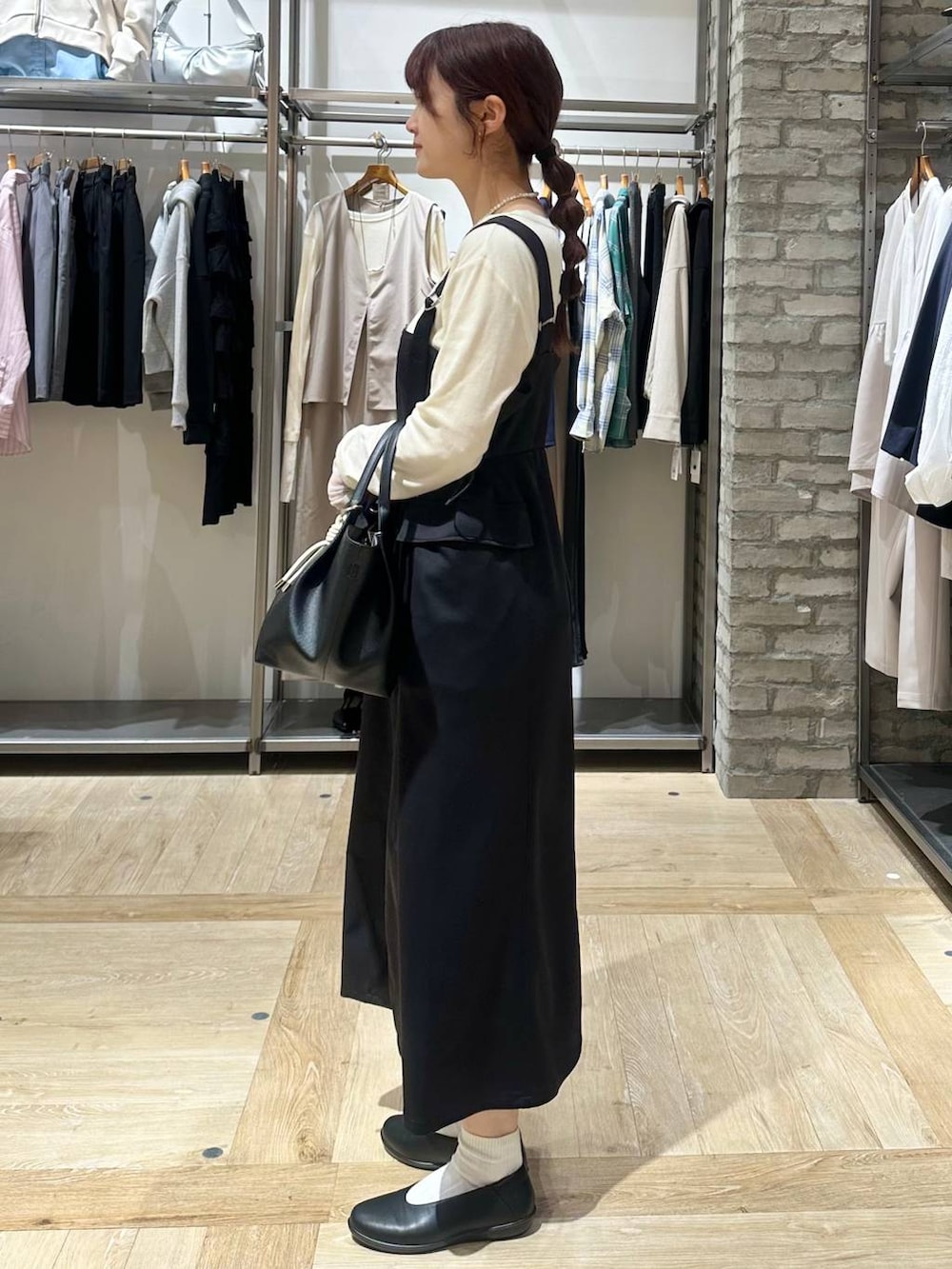 ホワイト系のTシャツ/カットソー、ブラック系のパンプス、ブラック系のトートバッグを着用したレディースの春コーディネートの2枚目の写真