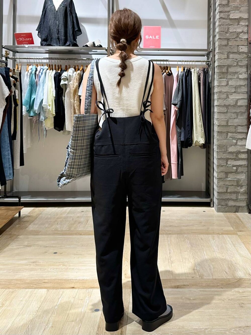 ホワイト系のTシャツ/カットソー、シルバー系のサンダル、ブラック系のサロペット/オーバーオールを着用したレディースの夏コーディネートの3枚目の写真