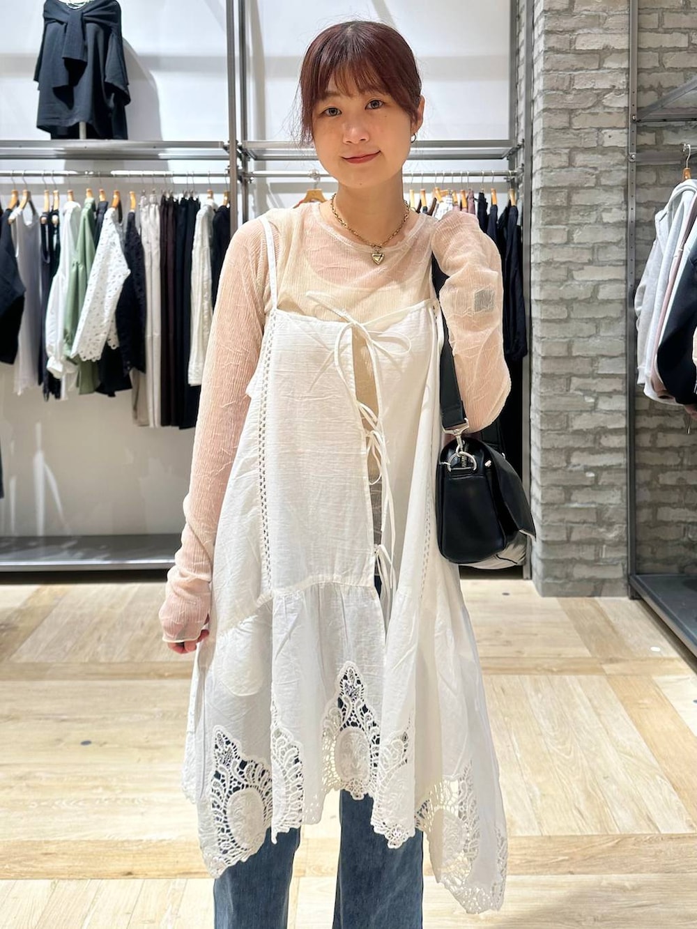 ブラック系のショルダーバッグ、ホワイト系のキャミソール、ブラック系のパンプスを着用したレディースの春コーディネートの4枚目の写真