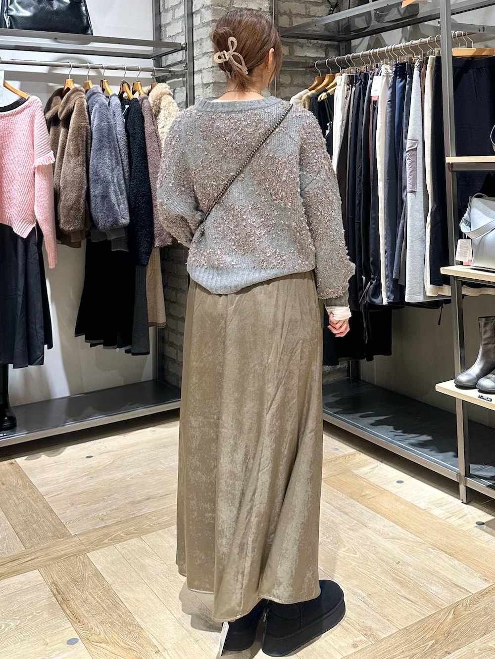 ブラック系のショルダーバッグ、ブラック系のその他アウター、ブラウン系のスカートを着用したレディースの秋コーディネートの3枚目の写真