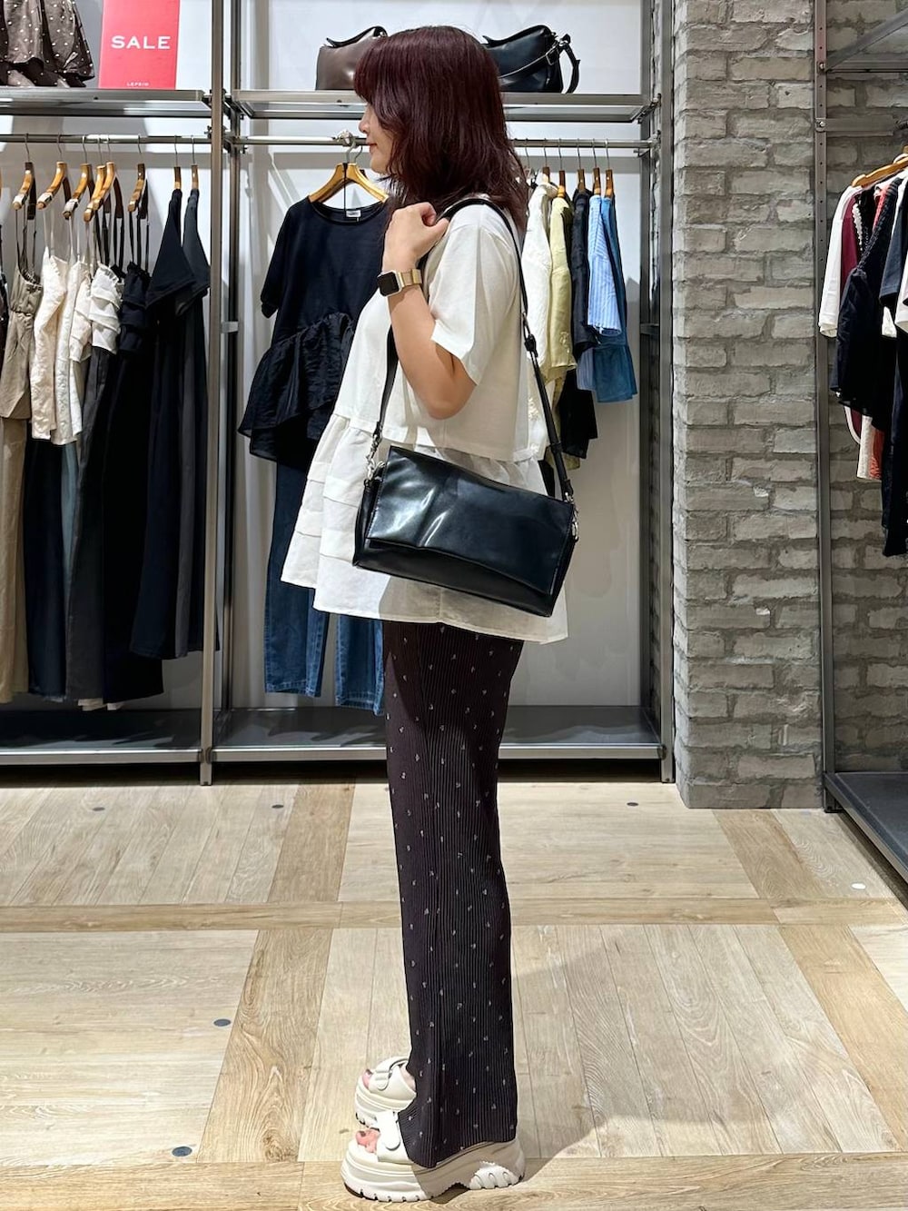 ブラウン系のその他パンツ、ブラック系のショルダーバッグ、ホワイト系のサンダルを着用したレディースの夏コーディネートの2枚目の写真