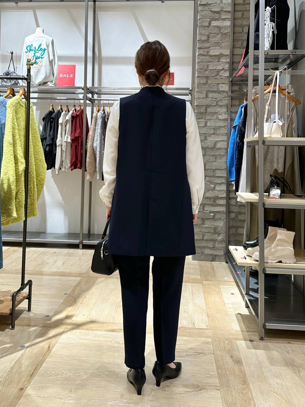 ブルー系のスーツパンツ、ブルー系のスーツベスト、ホワイト系のシャツ/ブラウスを着用したレディースの冬コーディネートの3枚目の写真