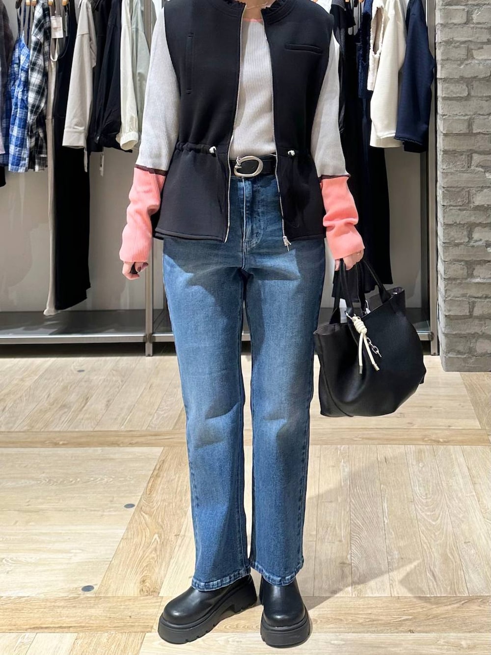 ブラック系のその他シューズ、ブラック系のトートバッグ、ブルー系のデニムパンツを着用したレディースの春コーディネートの5枚目の写真