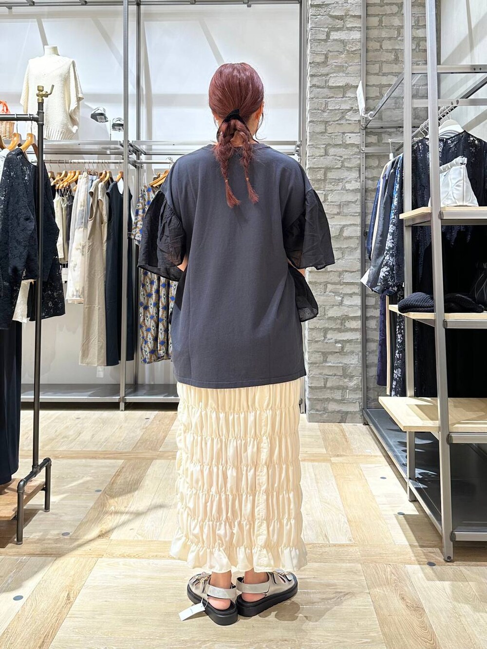 グレー系のTシャツ/カットソー、ホワイト系のスカート、シルバー系のサンダルを着用したレディースの夏コーディネートの4枚目の写真