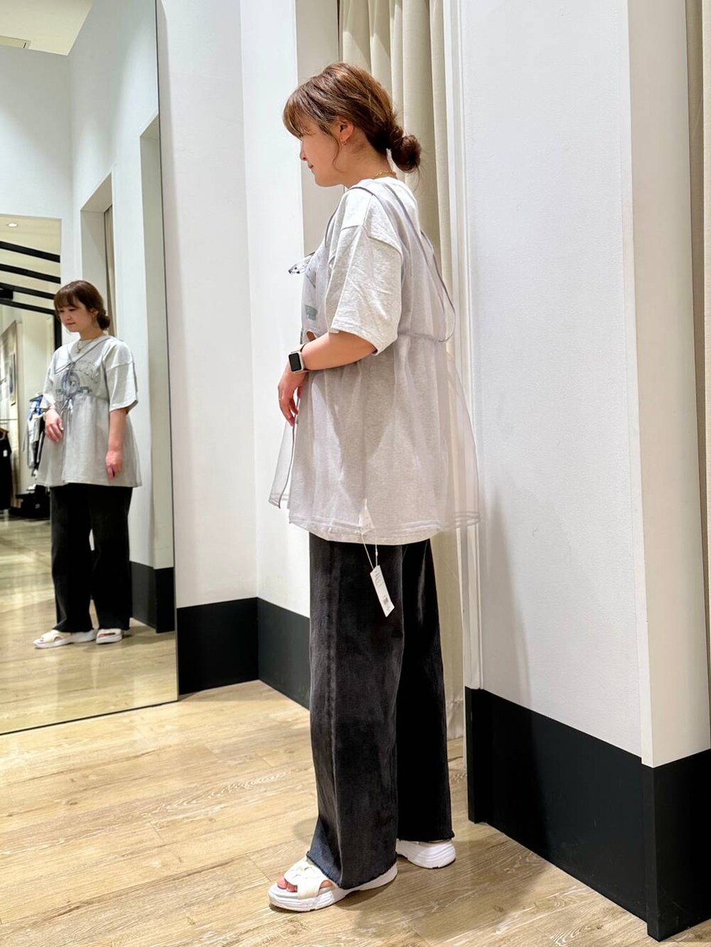 ホワイト系のサンダル、グレー系のベスト、ブラック系のデニムパンツを着用したレディースの春コーディネートの4枚目の写真