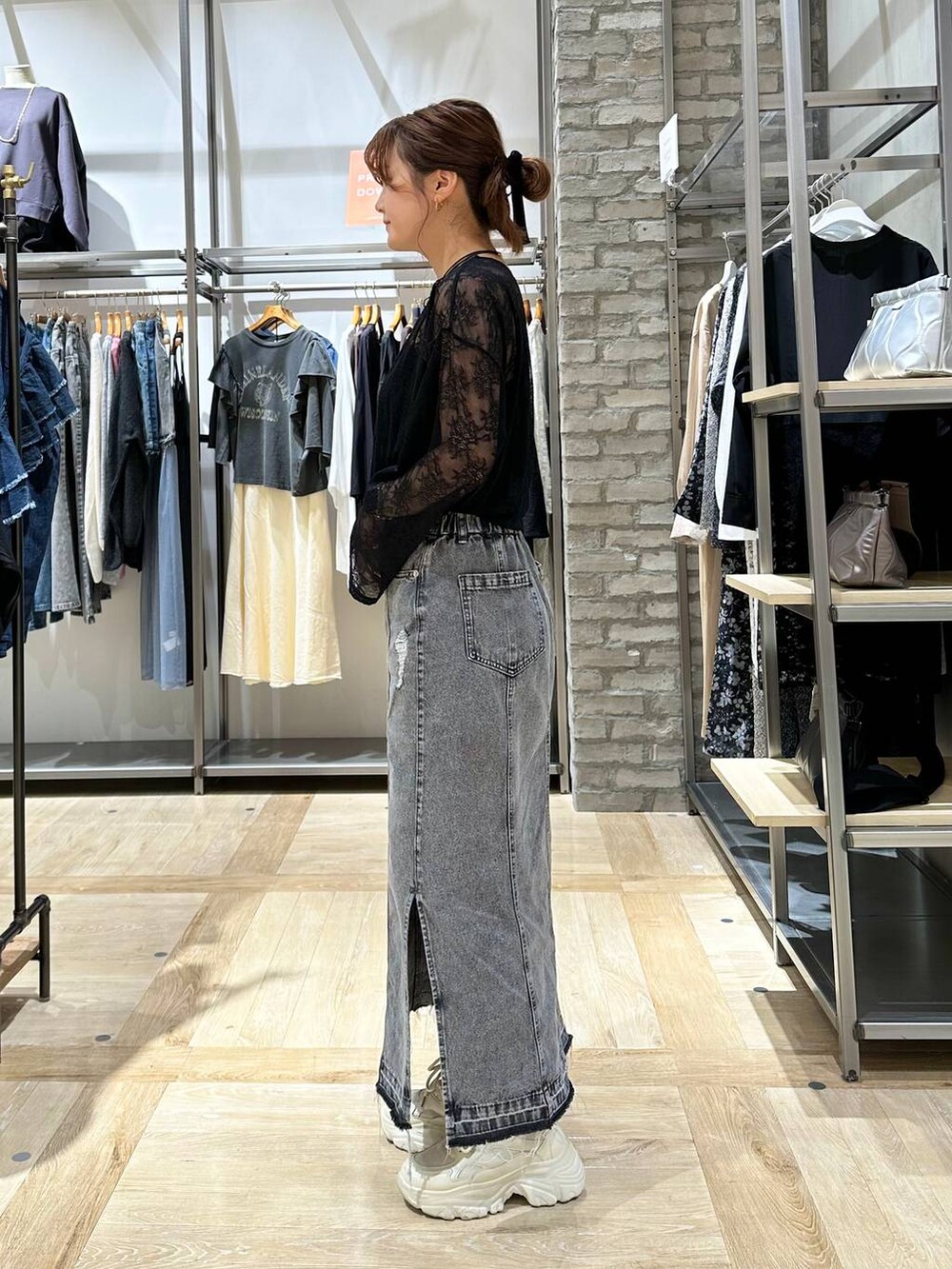 ホワイト系のスニーカー、グレー系のスカート、ブラック系のTシャツ/カットソーを着用したレディースの秋コーディネートの2枚目の写真