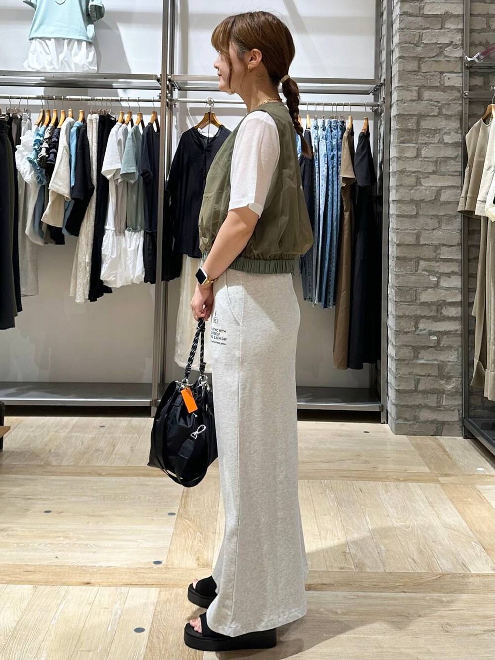 ブラック系のサンダル、グリーン系のその他アウター、グレー系のスカートを着用したレディースの夏コーディネートの2枚目の写真