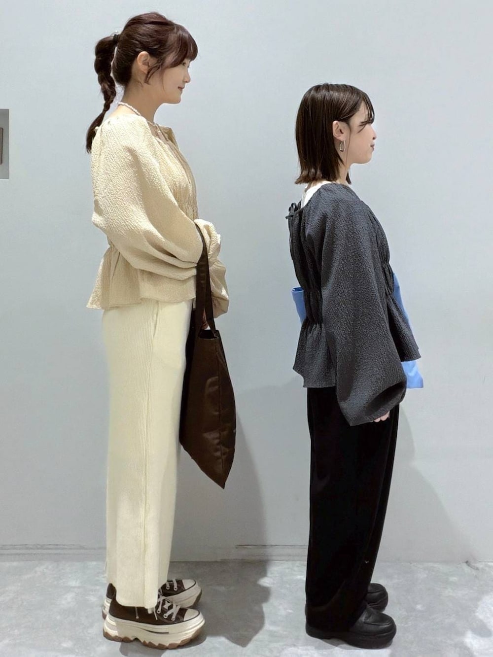 ホワイト系のスカート、ブラック系のスウェットパンツ、ブルー系のトートバッグを着用したレディースの春コーディネートの2枚目の写真