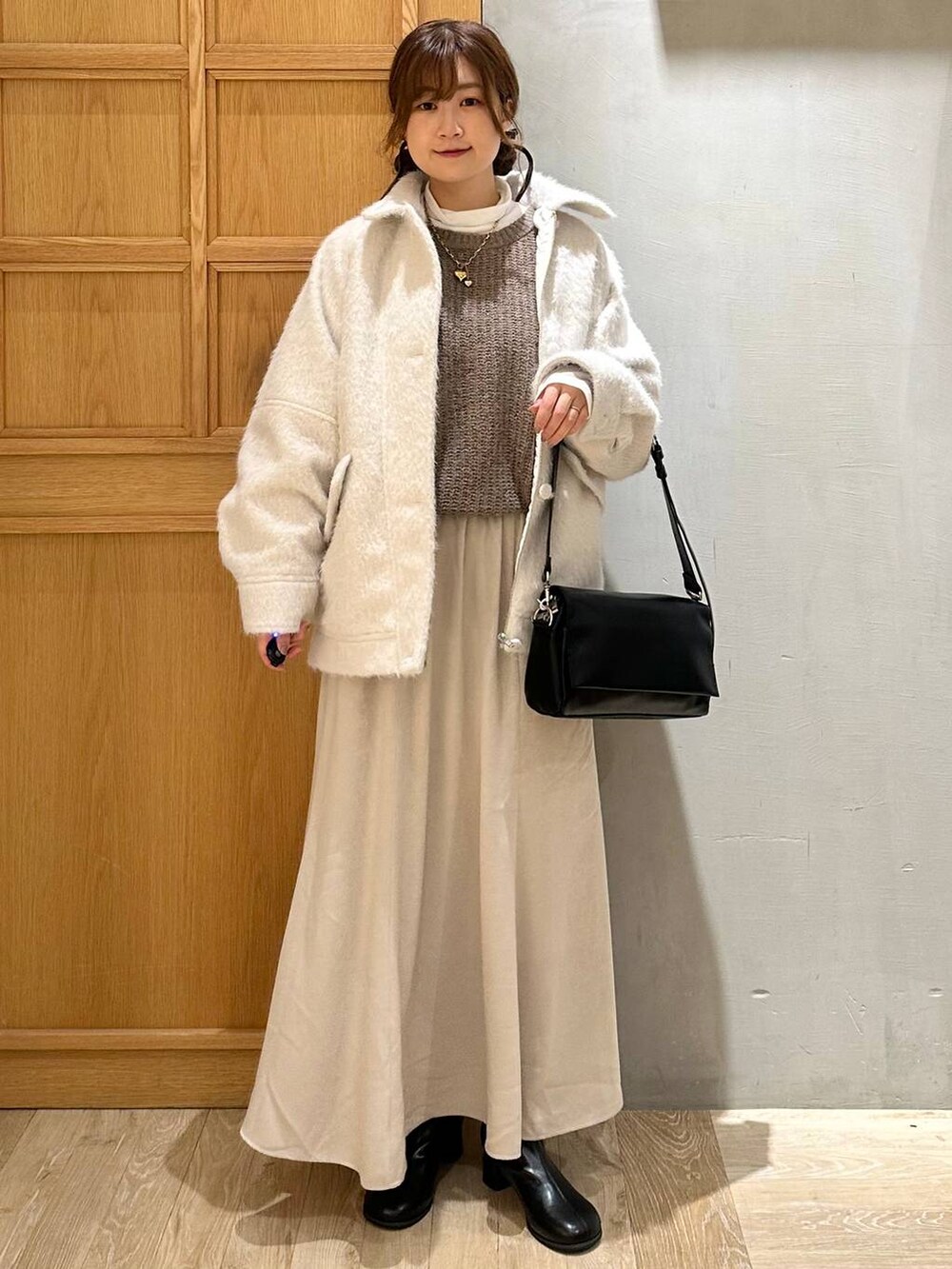 ホワイト系のTシャツ/カットソー、ブラック系のショルダーバッグ、ブラック系のブーツを着用したレディースの冬コーディネートの6枚目の写真