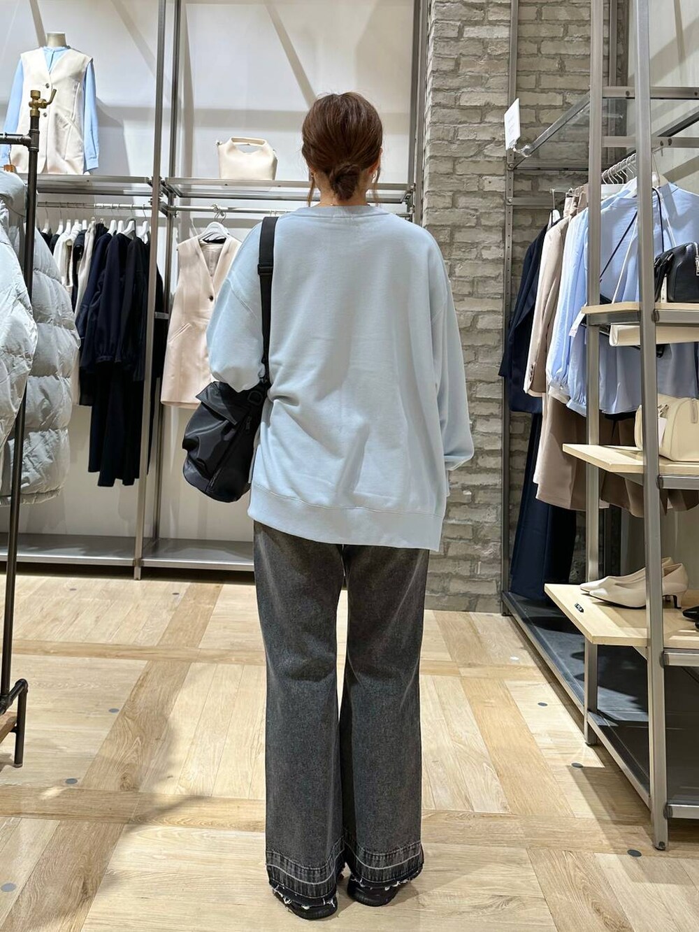 ブラック系のショルダーバッグ、ブラック系のスニーカー、ブルー系のスウェットを着用したレディースの冬コーディネートの3枚目の写真