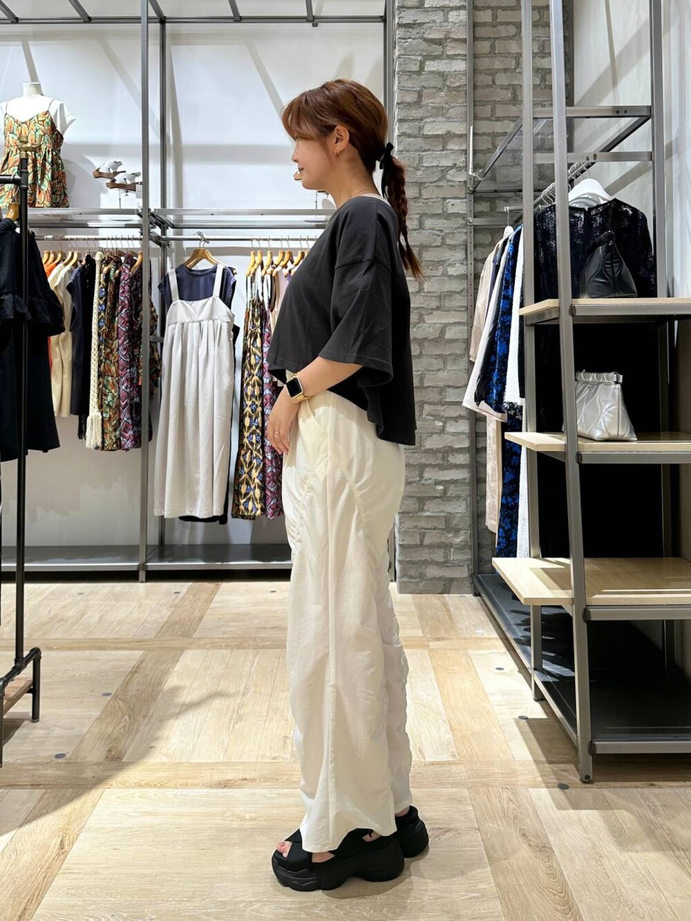 グレー系のTシャツ/カットソー、ブラック系のサンダル、グレー系のショルダーバッグを着用したレディースの夏コーディネートの3枚目の写真