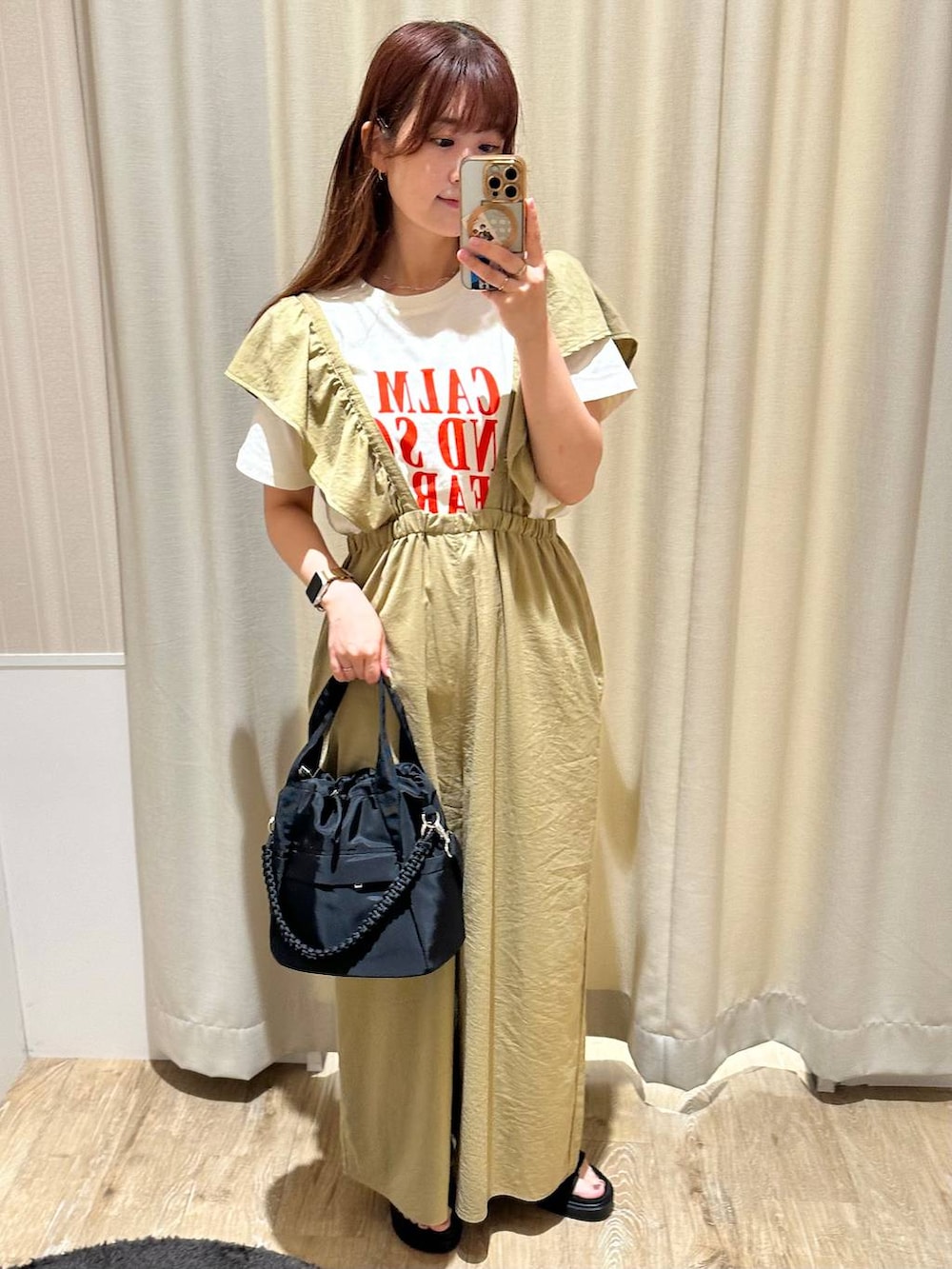ブラック系のショルダーバッグ、ブラック系のサンダル、ホワイト系のTシャツ/カットソーを着用したレディースの夏コーディネートの2枚目の写真
