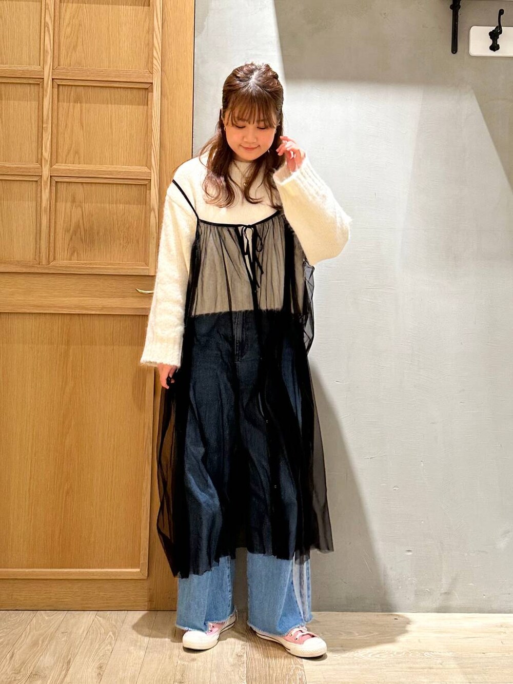 ブラック系のトートバッグ、ブルー系のデニムパンツ、ホワイト系のニット/セーターを着用したレディースの冬コーディネートの5枚目の写真