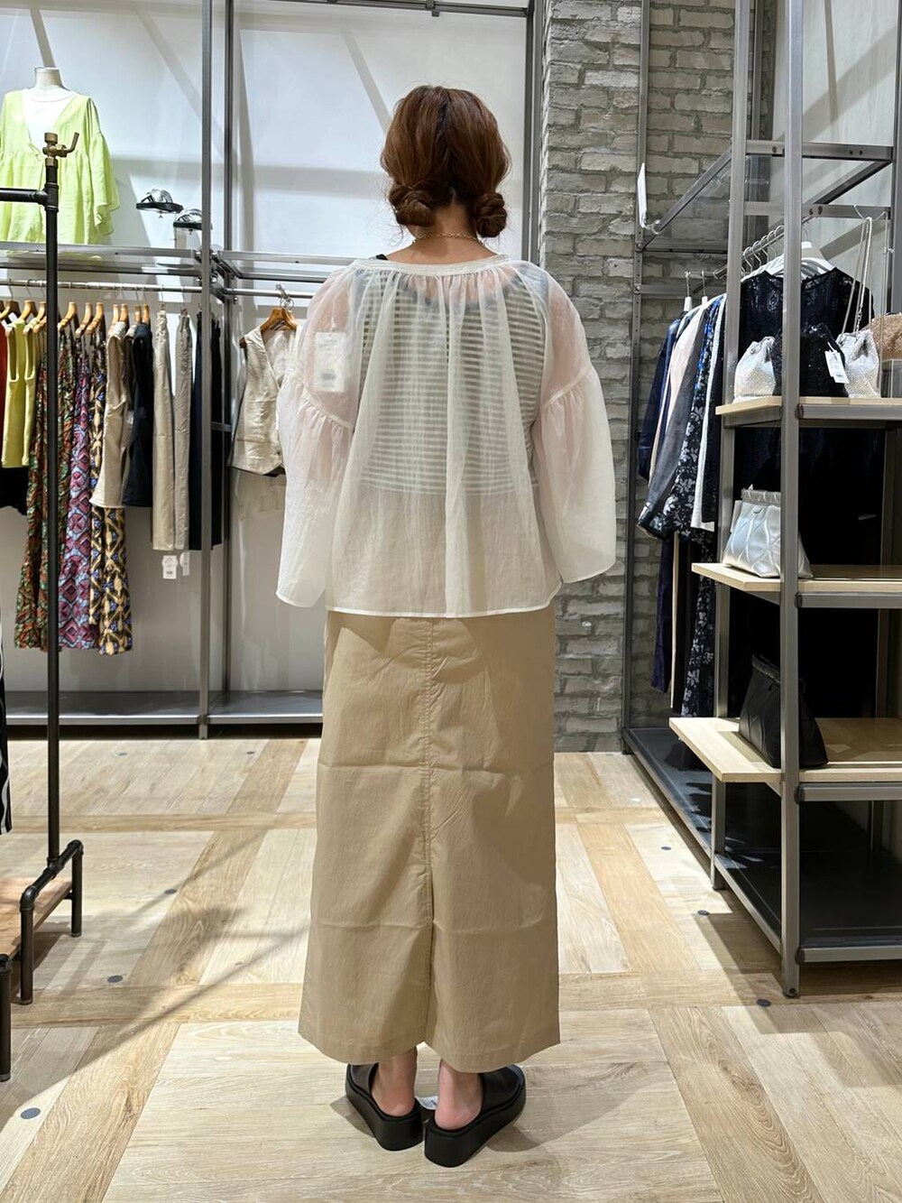 ブラック系のショルダーバッグ、ベージュ系のスカート、ブラック系のサンダルを着用したレディースの夏コーディネートの4枚目の写真