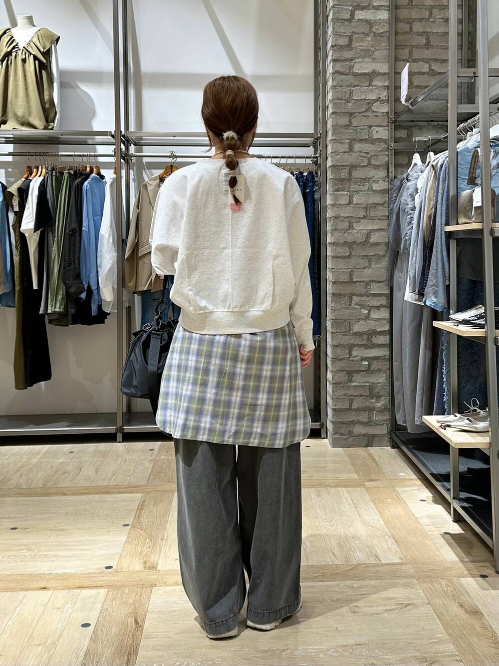 ブラック系のショルダーバッグ、ベージュ系のスニーカー、グレー系のTシャツ/カットソーを着用したレディースの春コーディネートの2枚目の写真