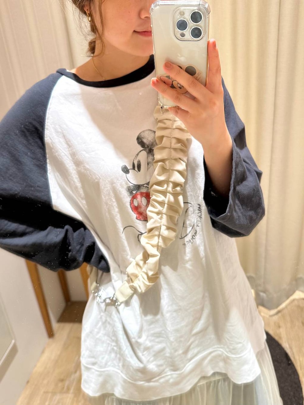 ホワイト系のスカート、ブラック系のTシャツ/カットソー、ブルー系のデニムパンツを着用したレディースの春コーディネートの2枚目の写真