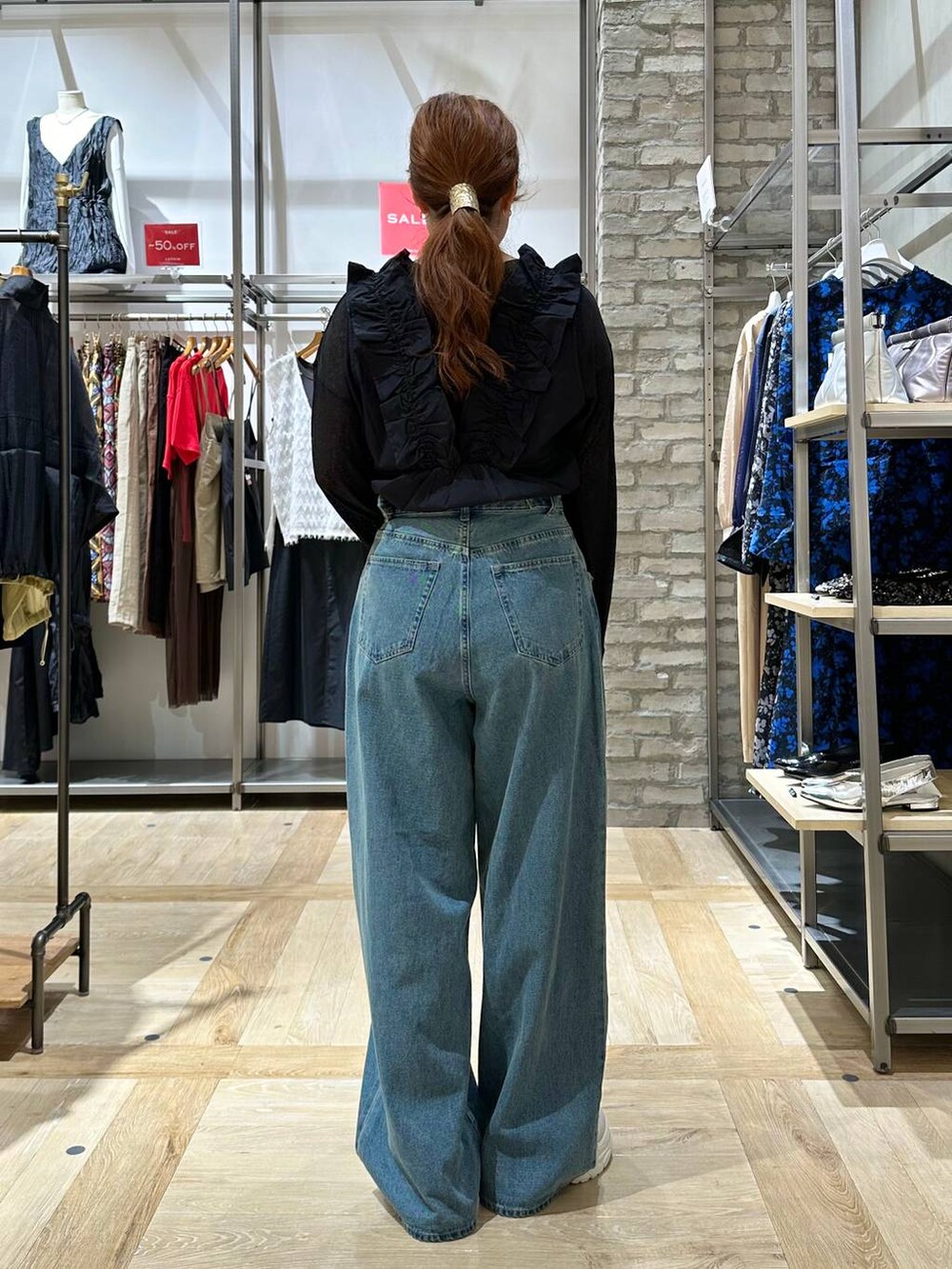 ブラック系のTシャツ/カットソー、ブルー系のデニムパンツ、ホワイト系のスニーカーを着用したレディースの夏コーディネートの3枚目の写真