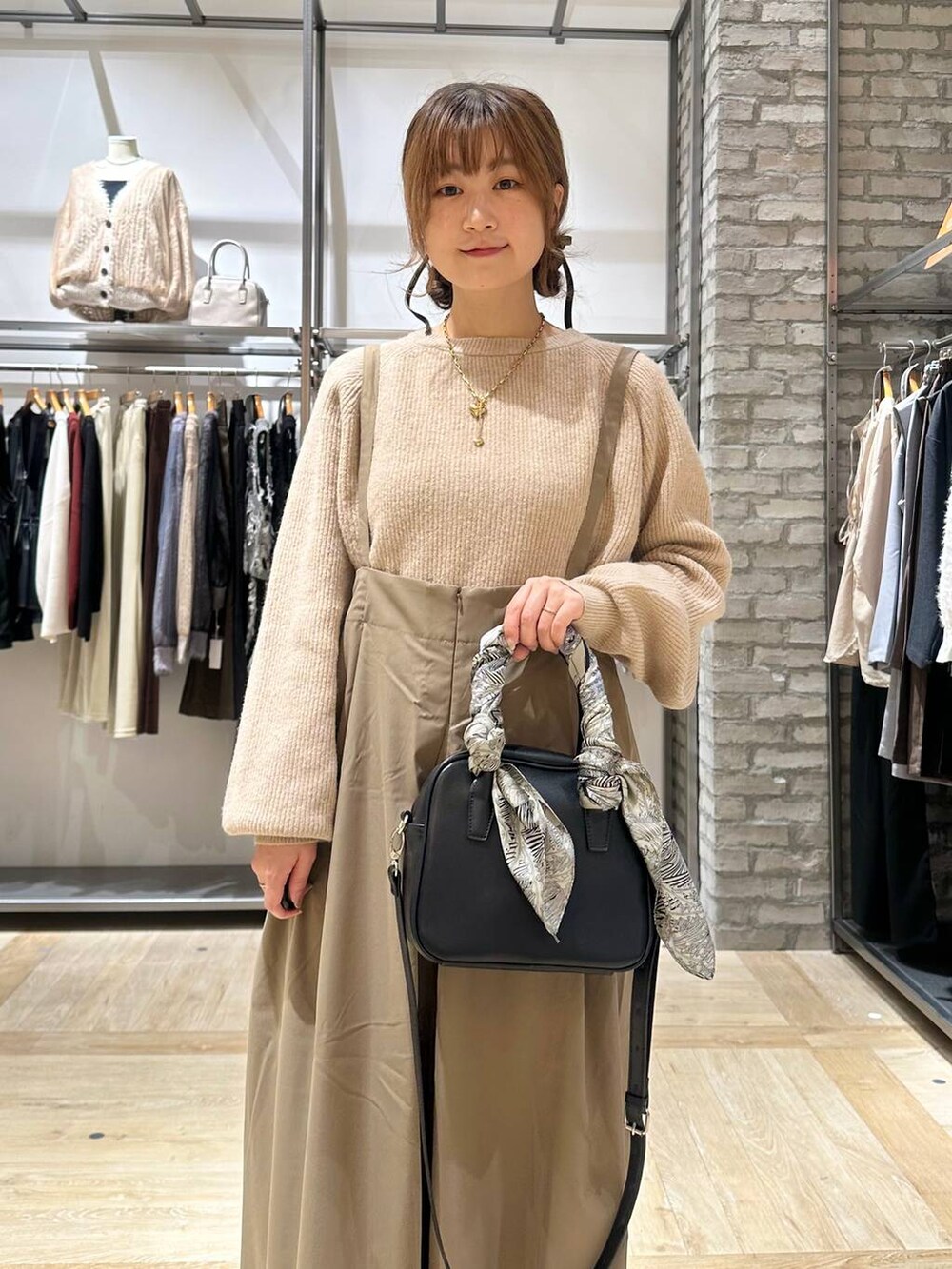 ベージュ系のニット/セーター、ブラック系のボストンバッグ、ブラック系のブーツを着用したレディースの秋コーディネートの5枚目の写真