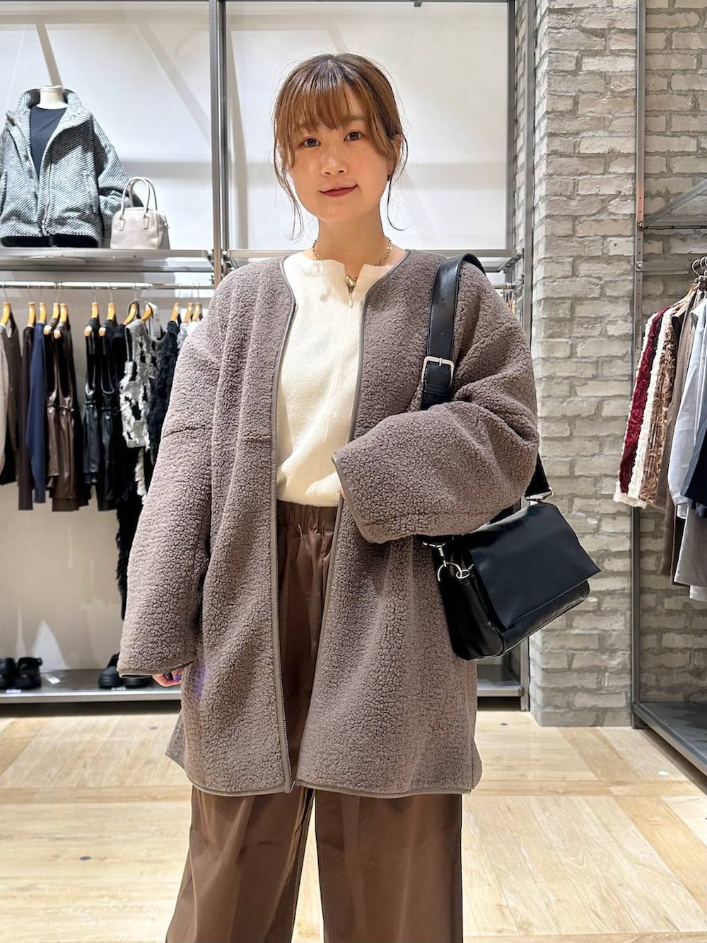 ホワイト系のニット/セーター、ブラック系のショルダーバッグ、ブラウン系のその他パンツを着用したレディースの秋コーディネートの4枚目の写真