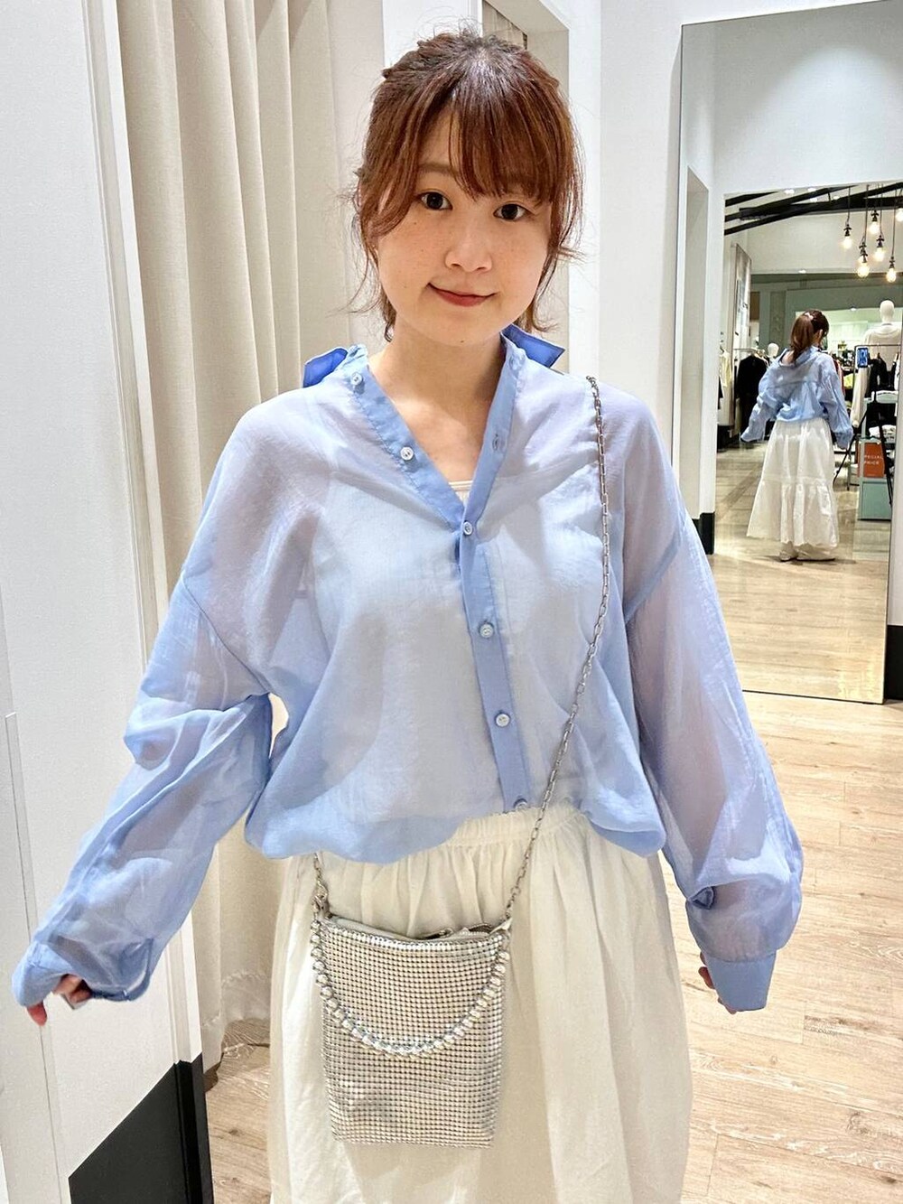 ブルー系のシャツ/ブラウス、ホワイト系のスカート、シルバー系のショルダーバッグを着用したレディースの春コーディネートの4枚目の写真