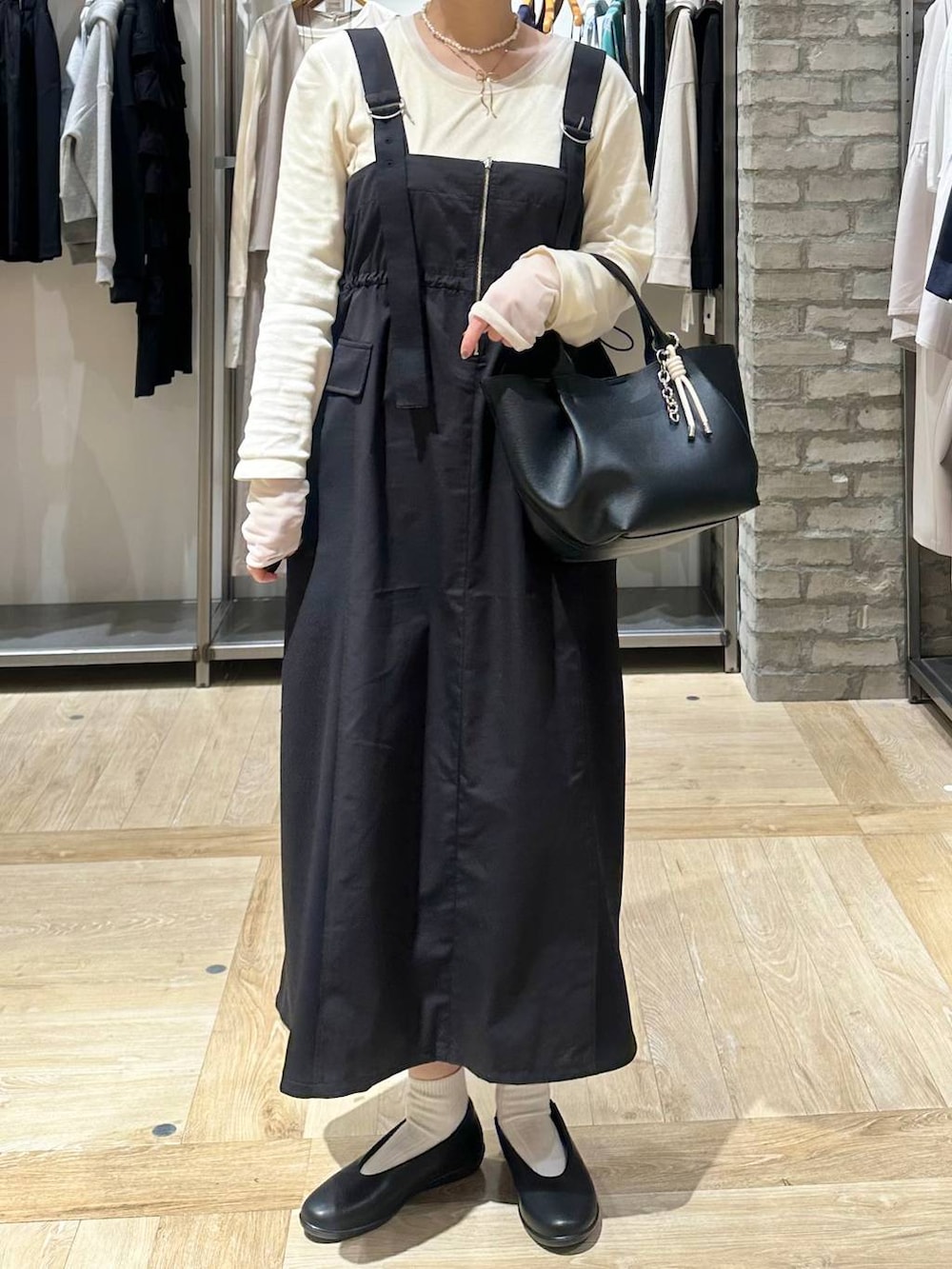 ホワイト系のTシャツ/カットソー、ブラック系のパンプス、ブラック系のトートバッグを着用したレディースの春コーディネートの5枚目の写真