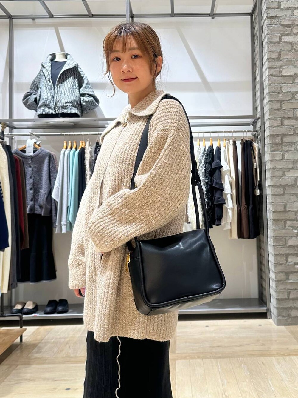 ブラウン系のブーツ、ホワイト系のTシャツ/カットソー、ブラック系のショルダーバッグを着用したレディースの秋コーディネートの7枚目の写真