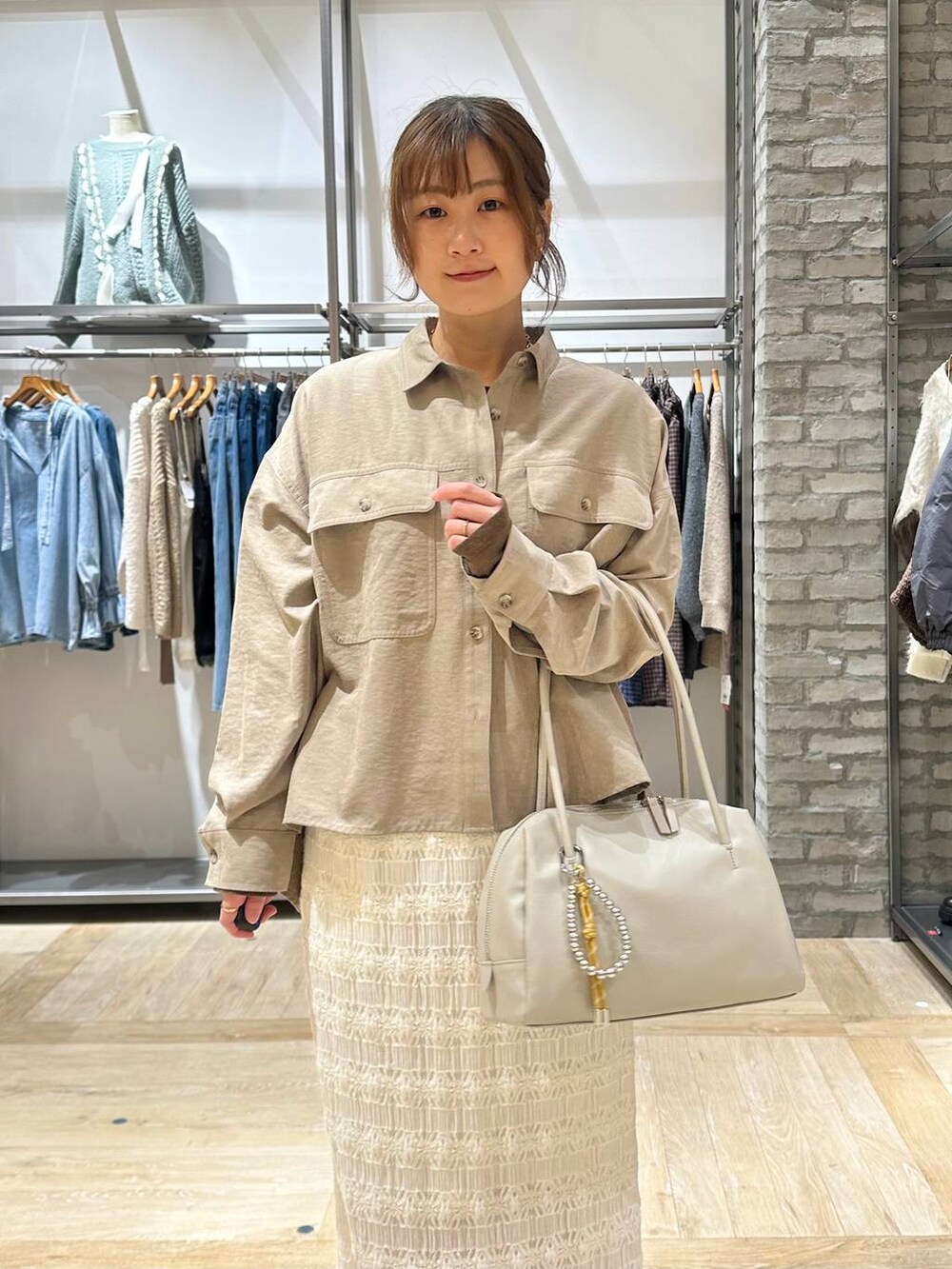 ホワイト系のスカート、ベージュ系のシャツ/ブラウス、ホワイト系のボストンバッグを着用したレディースの冬コーディネートの4枚目の写真