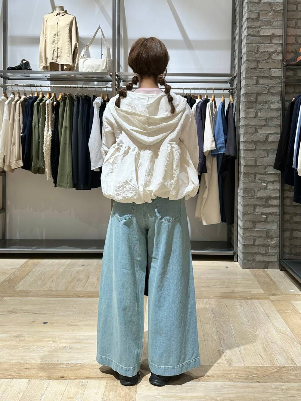 ブラック系のショルダーバッグ、ピンク系のTシャツ/カットソー、ブルー系のデニムパンツを着用したレディースの春コーディネートの3枚目の写真