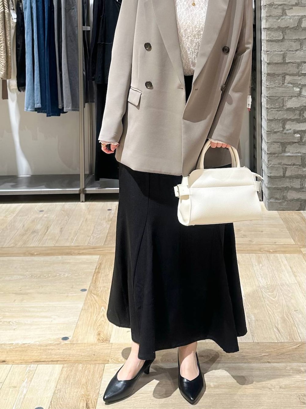 ブラウン系のテーラードジャケット、ホワイト系のTシャツ/カットソー、ブラック系のパンプスを着用したレディースの冬コーディネートの5枚目の写真