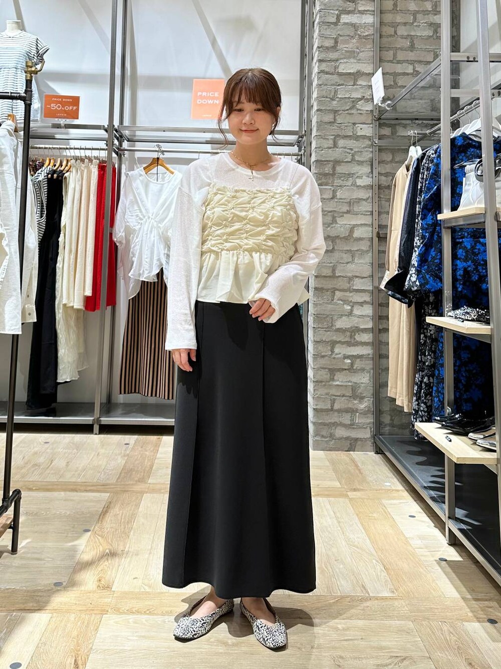 ホワイト系のTシャツ/カットソー、ブラック系のボストンバッグ、ホワイト系のパンプスを着用したレディースの夏コーディネートの2枚目の写真