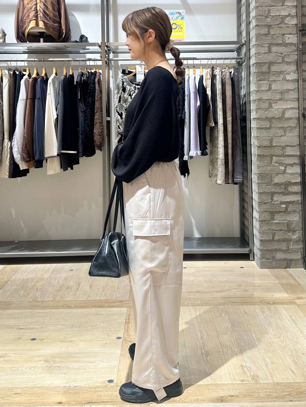 ブラック系のニット/セーター、ブラック系のスニーカー、ホワイト系のその他パンツを着用したレディースの秋コーディネートの3枚目の写真