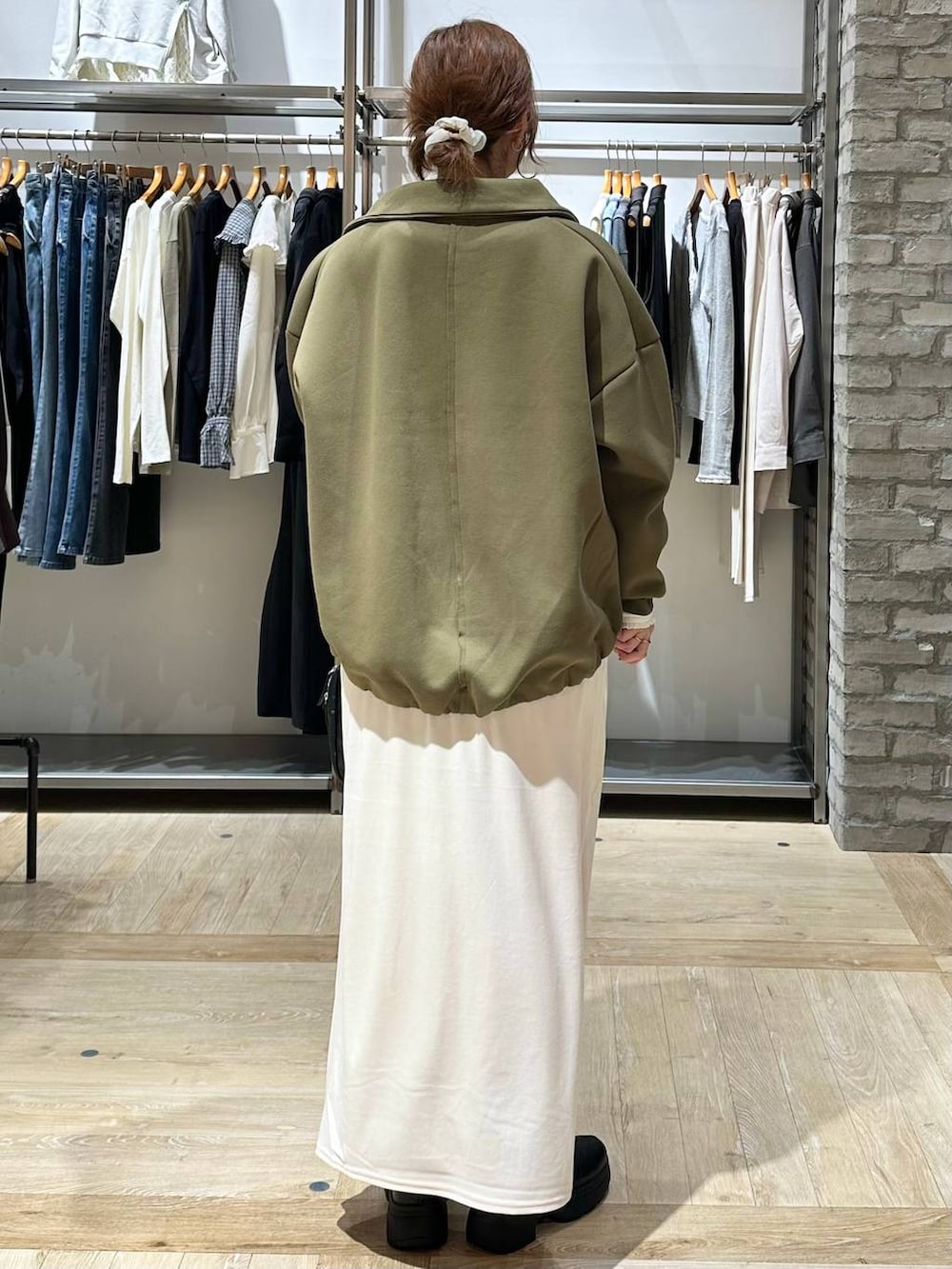 ブラック系のボストンバッグ、ブラック系のブーツ、ホワイト系のTシャツ/カットソーを着用したレディースの秋コーディネートの3枚目の写真