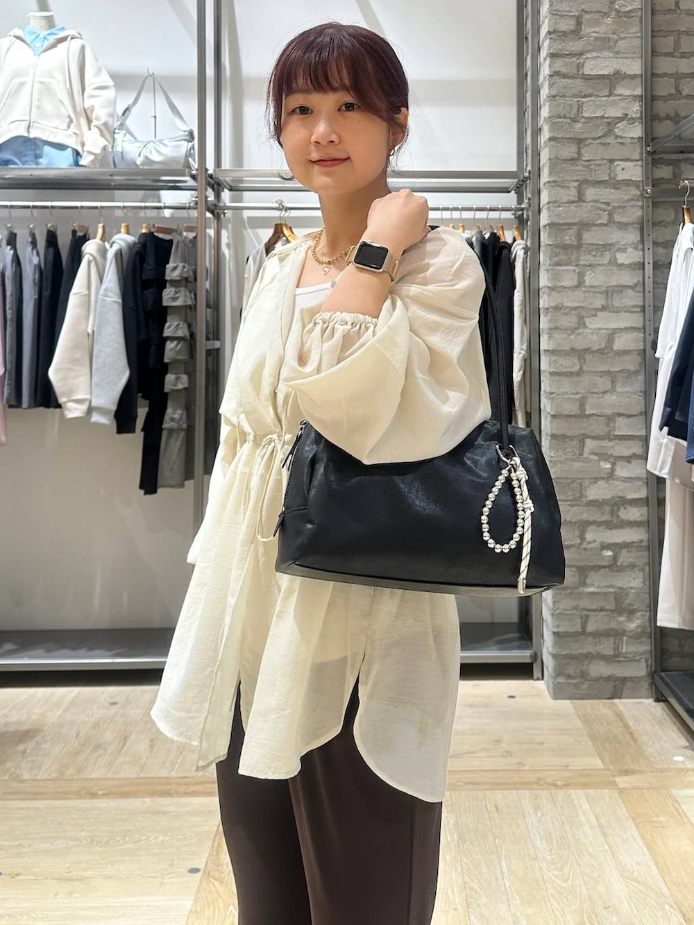 ブラック系のボストンバッグ、ホワイト系のシャツ/ブラウス、ブラウン系のその他パンツを着用したレディースの春コーディネートの4枚目の写真