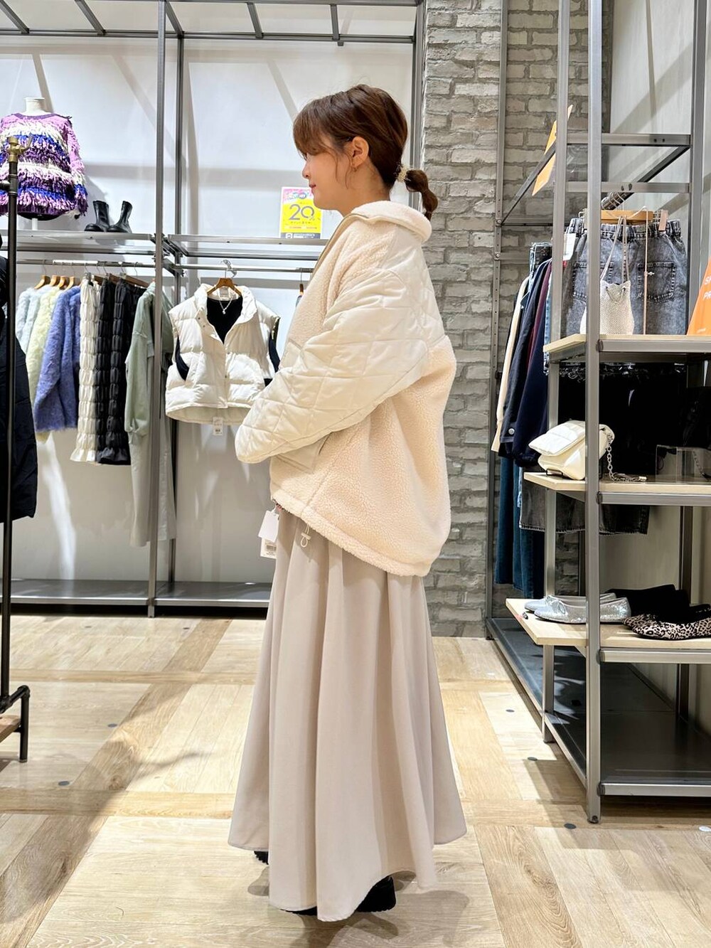 グリーン系のニット/セーター、ブラック系のブーツ、ホワイト系のブルゾンを着用したレディースの秋コーディネートの2枚目の写真