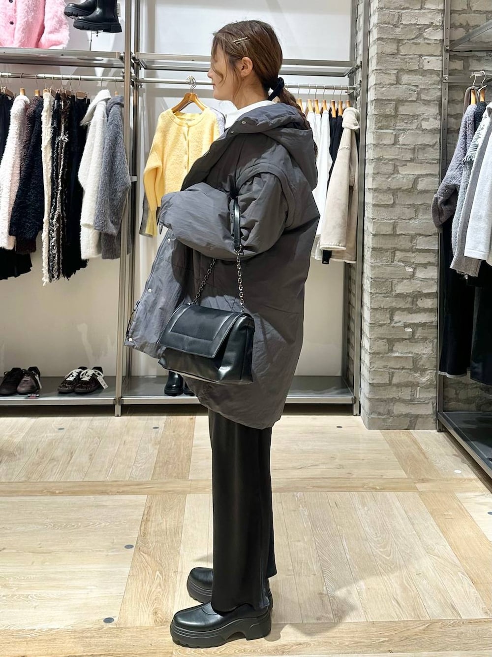 ブラック系のスカート、グレー系のその他アウター、ブラック系のブーツを着用したレディースの冬コーディネートの2枚目の写真