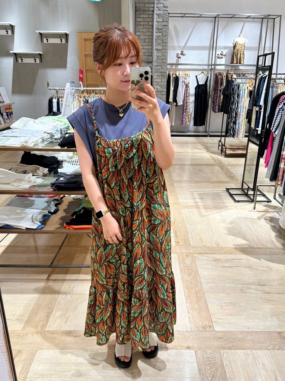 グレー系のTシャツ/カットソー、ホワイト系のサンダル、オレンジ系のワンピースを着用したレディースの夏コーディネートの2枚目の写真