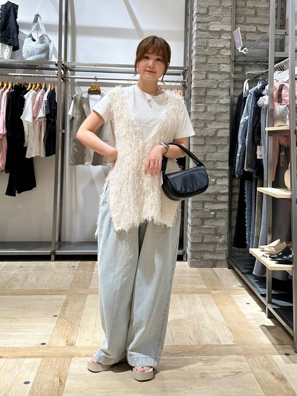 ホワイト系のTシャツ/カットソー、ホワイト系のサンダル、ブラック系のハンドバッグを着用したレディースの春コーディネートの2枚目の写真