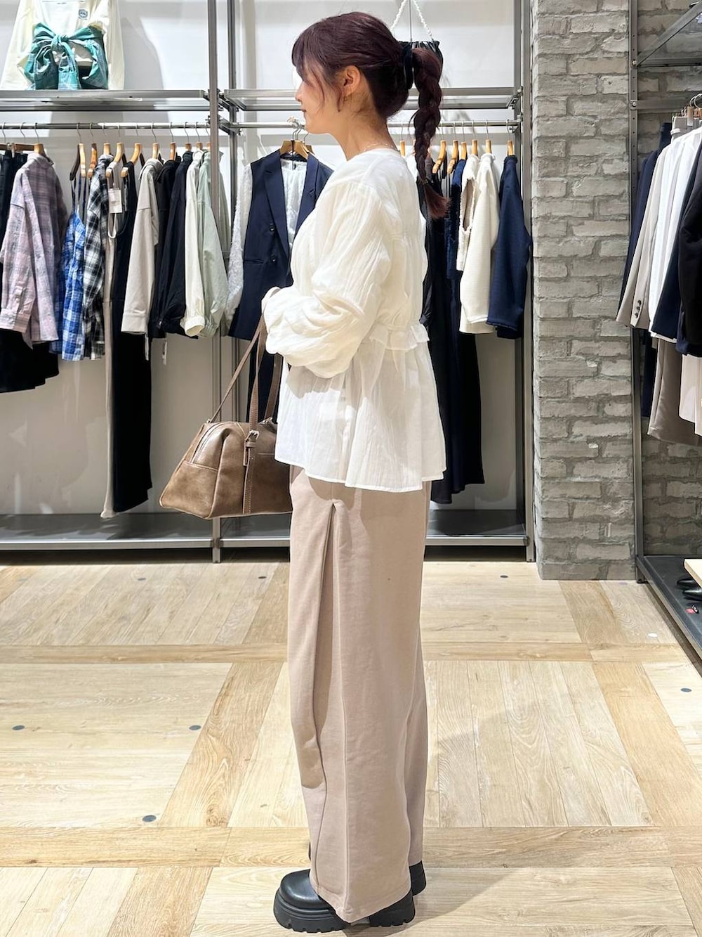 ブラウン系のボストンバッグ、ホワイト系のTシャツ/カットソー、ベージュ系のスウェットパンツを着用したレディースの春コーディネートの2枚目の写真