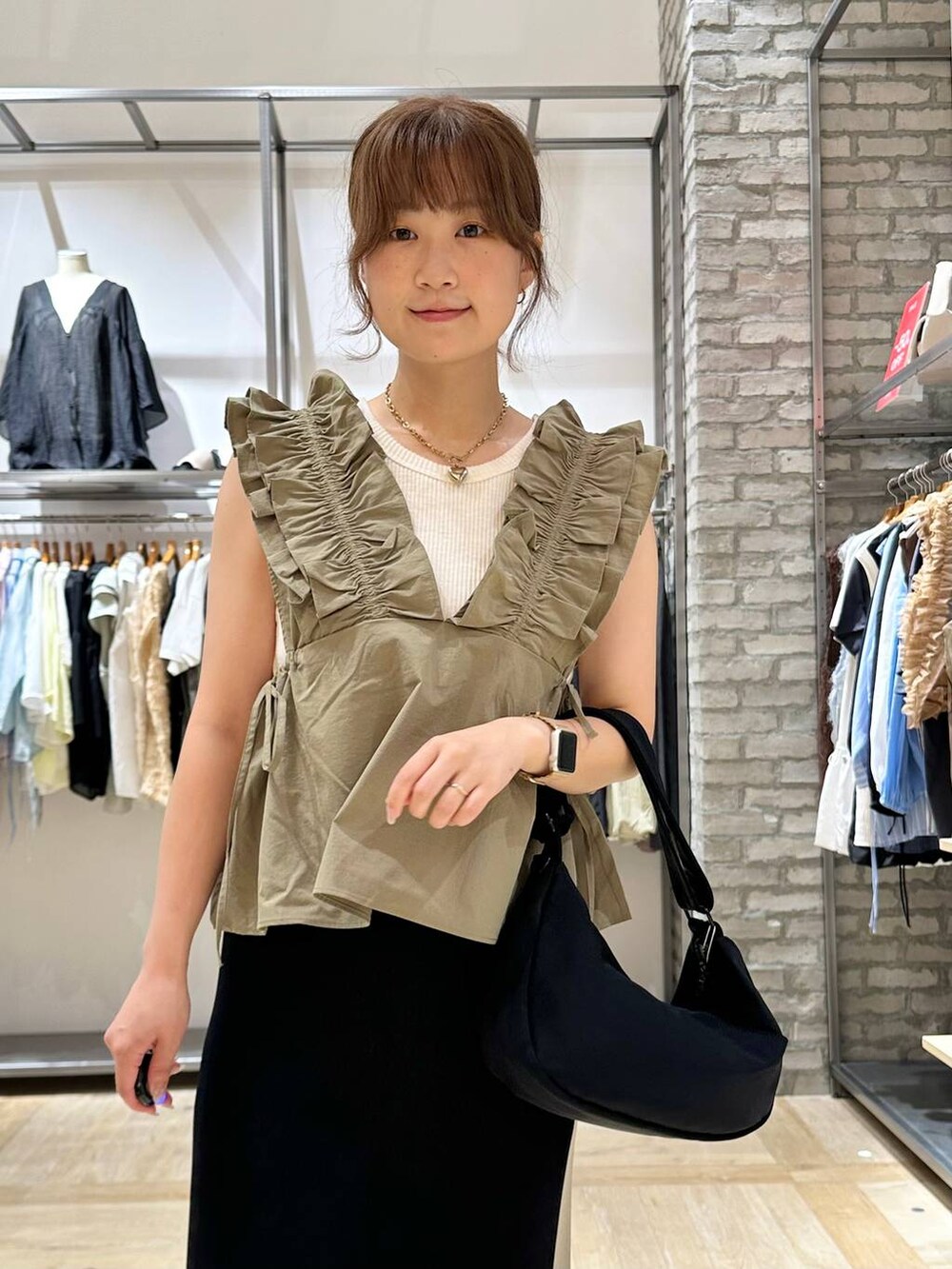 ホワイト系のTシャツ/カットソー、ブラック系のスカート、ホワイト系のサンダルを着用したレディースの夏コーディネートの4枚目の写真