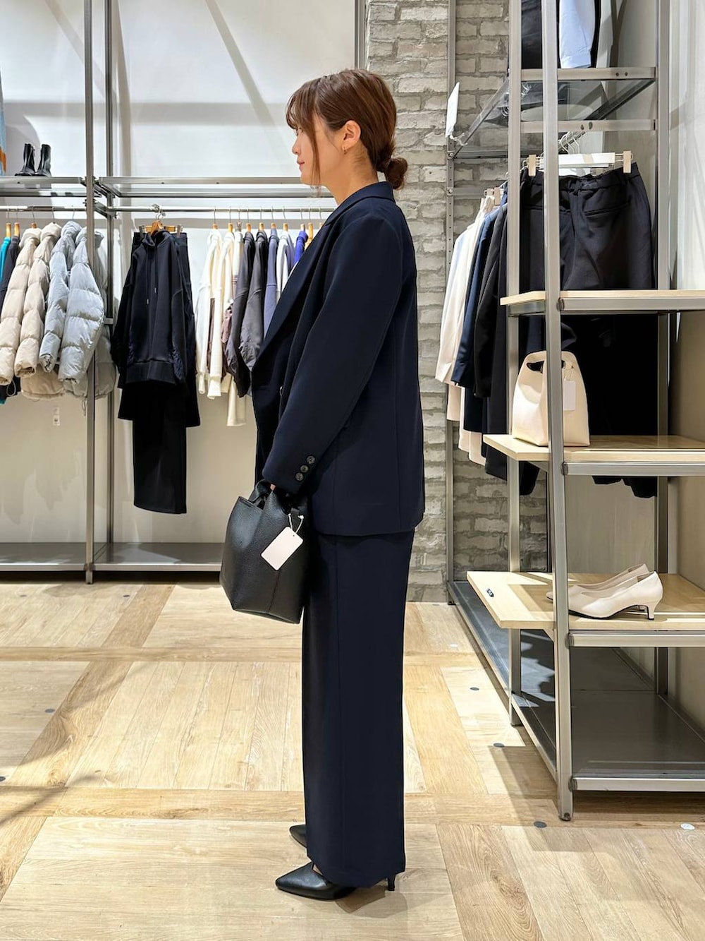 ブルー系のスーツパンツ、ホワイト系のシャツ/ブラウス、ブラック系のパンプスを着用したレディースの冬コーディネートの2枚目の写真